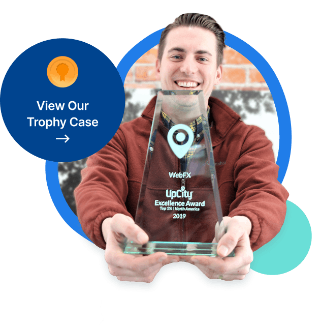 A smiling person holding a clear glass trophy with the text 'AIFLOTRIX UpCity Excellence Award Top 1% North America 2019'.